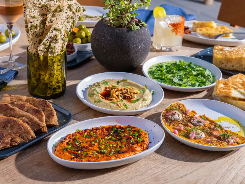 A long table of shared plates and breads at 1 Hotel West Hollywood